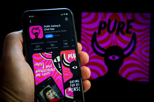 Apple App Store auf einem iPhone. Essenzielle Dating Apps. Pure: Dating & Chat App. Das iPhone wird in der Hand gehalten.. 06.09.2026