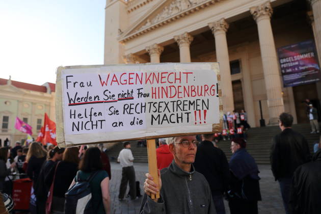 Ein Demonstrant mit Schild Frau Wagenknecht: Werden Sie nicht Frau Hindenburg! Helfen Sie Rechtsextremen nicht an die Macht! während einer Kundgebung gegen die Partei Alternative für Deutschland AfD nach deren Wahlsieg bei der Landtagswahl in Sachsen-Anhalt, Alter Markt, Potsdam, 7. September 2026. Kundgebung gegen AfD in Potsdam