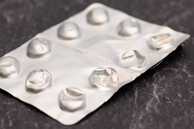 Leere Blisterpackung ohne Tabletten , Waldsee, Deutschland 13.09.2026: Alle Tabletten sind aus einer Blisterpackung herausgedrückt, die leere Folie liegt auf einem dunklen Steinuntergrund. Symbolbild für Magensäureblocker wie Pantoprazol.