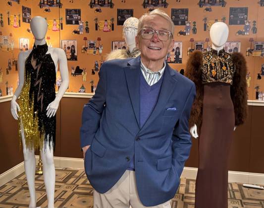 December 2, 2024, New York, New York, USA: American fashion designer and costumier BOB MACKIE seen with his creations, (L-R) Bob Mackie 1987 Archival Earthquake dress worn by Pink during the 2022 AMA Awards, estimate $5000 - $6000, and two-piece evening ensemble designed by Bob Mackie for Cher worn numerous times for publicity images, and The Sonny and Cher Show, where Cher covered Ethel Waters 1933 song ‘Stormy Weather,â€⠢ August 22, 1971 estimate $3,000 and $5,000, seen during the press preview for the Hollywood Legends ‘Unmistakably Mackieâ€⠢ auction presented by Julienâ€⠢s Auctions and Turner Classic Movies held at the Carlyle Hotel. New York USA - ZUMAk03_ 20241202_zaf_k03_077 Copyright: xNancyxKaszermanx