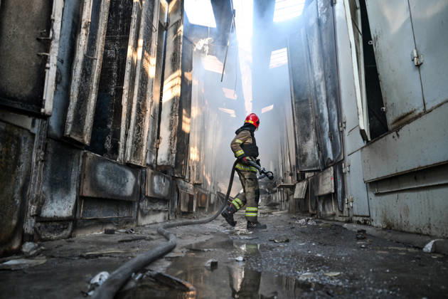 A State Emergency Service rescuer carries a fire hose as he walks along a smoke-filled passageway to extinguish a fire at the Central Clothes Market (Anholenko) in Zaporizhzhia, Ukraine, September 26, 2026. The market sustained significant damage in a Russian drone attack. (Photo by Dmytro Smolienko Ukrinform) Russian troops strike clothes market in Zaporizhzhia  Copyright: xDmytroxSmolienkox