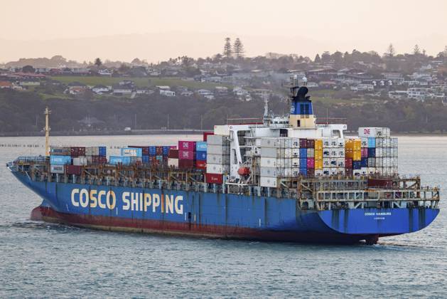 Das Containerschiff Cosco Hamburg überquert Aucklands Waitemat? Harbour in warmem Abenddämmerungslicht. Sein blauer Rumpf und die Cosco Shipping Lackierung fangen den goldenen Schimmer ein, als das Schiff das Containerterminal Ports of Auckland hinter den Küstenhügeln, Waitemata Harbour, Auckland, Neuseeland, verlässt The container ship Cosco Hamburg crosses Auckland s Waitemat? Harbour in warm dusk light, its blue hull and Cosco Shipping livery catching the golden glow as the vessel departs the Ports of Auckland container terminal past coastal hills, Waitemata Harbour, Auckland, New Zealand Copyright: imageBROKER DavidxRowland iblbmv19290140.jpg