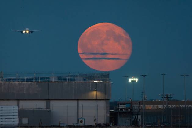 Vollmond am Frankfurter Flughafen Der Vollmond geht über dem Frankfurter Flughafen auf, während sich ein Flugzeug im Landeanflug befindet. Frankfurt am Main Flughafen Hessen Deutschland
