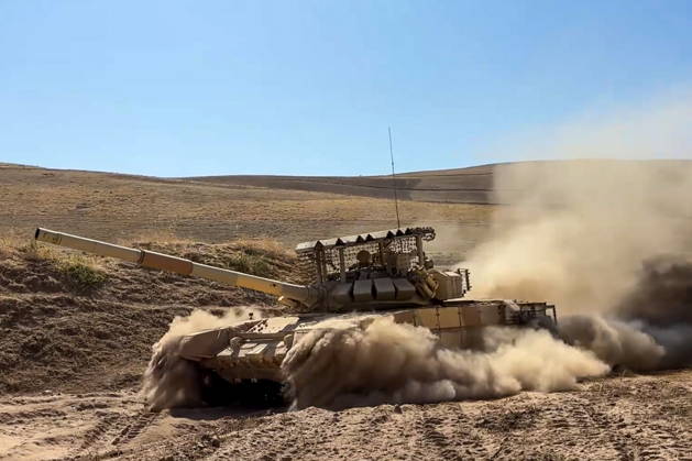 TAJIKISTAN - OCTOBER 3, 2026: Russian tank crews destroy a simulated enemy during the Tsentr Centre 2026 military exercise held at the Lyaur training ground. Video screen grab. Best quality available. Russian Defence Ministry TASS  98708964