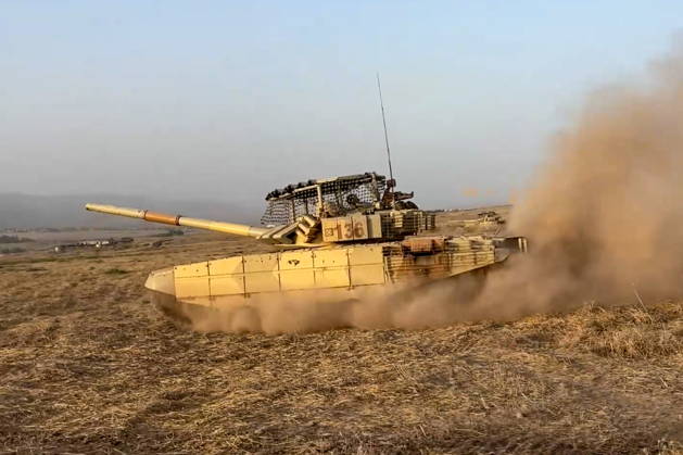 TAJIKISTAN - OCTOBER 3, 2026: Russian tank crews destroy a simulated enemy during the Tsentr Centre 2026 military exercise held at the Lyaur training ground. Video screen grab. Best quality available. Russian Defence Ministry TASS  98708966