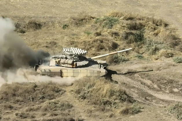 TAJIKISTAN - OCTOBER 3, 2026: Russian tank crews destroy a simulated enemy during the Tsentr Centre 2026 military exercise held at the Lyaur training ground. Video screen grab. Best quality available. Russian Defence Ministry TASS  98708968