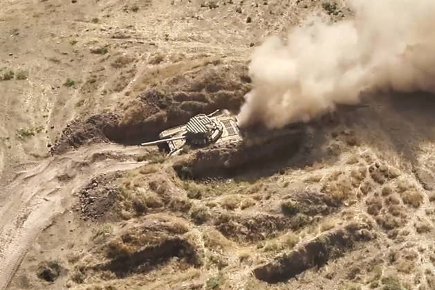 TAJIKISTAN - OCTOBER 3, 2026: Russian tank crews destroy a simulated enemy during the Tsentr Centre 2026 military exercise held at the Lyaur training ground. Video screen grab. Best quality available. Russian Defence Ministry TASS  98708970