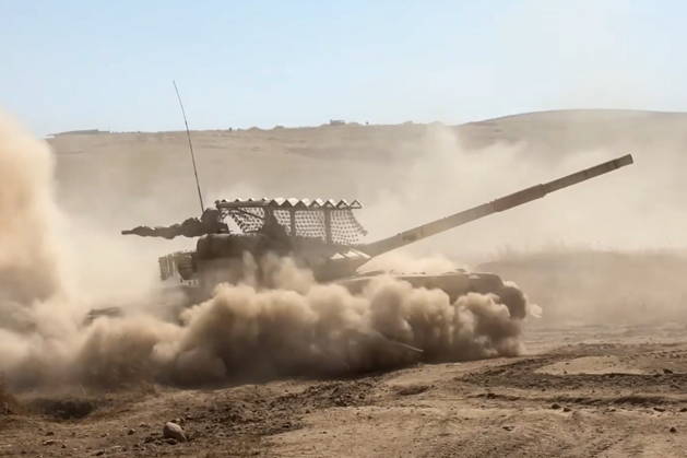 TAJIKISTAN - OCTOBER 3, 2026: Russian tank crews destroy a simulated enemy during the Tsentr Centre 2026 military exercise held at the Lyaur training ground. Video screen grab. Best quality available. Russian Defence Ministry TASS  98708974