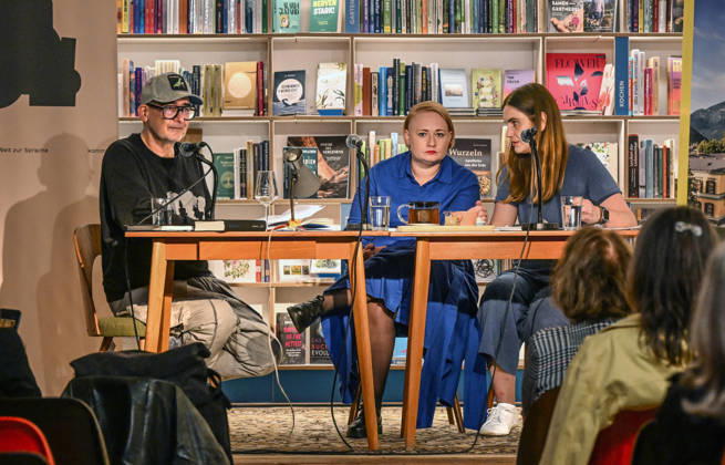 Minifestival AH0J (Literaturfestival) - Tschechien setzt über - der Kulturinitiative Literaturschiff, in der Buchhandlung Kurdirektion in Bad Ischl. Lesungen und Gespräche in Korrespondenz zum Gastauftritt Tschechiens auf der Frankfurter Buchmesse 2026. Es liest die tschechische Schriftstellerin Anna Bloch-Stickova Bloch-Å tiÄkova). Die Veranstaltung wird moderiert von Michael Stavaric (StavariÄ), fotografiert am 02.10.26., fotografiert am 02.10.26. Das Bild zeigt v.l.n.r: Moderator Michael Stavaric (StavariÄ), die Schriftstellerin Anna-Bloch-Stickova (Bloch-Å tiÄkova) mit der Konsekutivbersetzerin Lena Kurz 2026 - Minifestival AH0J (Literaturfestival) - Tschechien setzt über - der Kulturinitiative Literaturschiff, in der Buchhandl