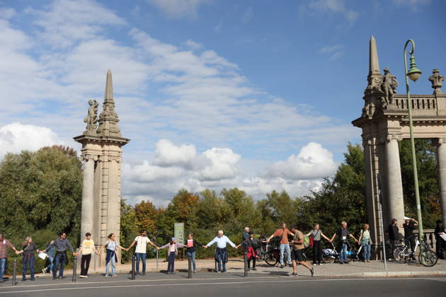 Demonstranten während einer Menschenkette für Klimaschutz und Demokratie auf der Glienicker Brücke in Potsdam, 3. Oktober 2026. Es brennt! Menschenkette Potsdam