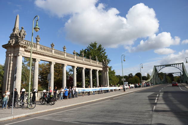 Demonstranten während einer Menschenkette für Klimaschutz und Demokratie auf der Glienicker Brücke in Potsdam, 3. Oktober 2026. Es brennt! Menschenkette Potsdam