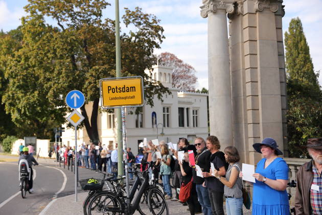 Demonstranten während einer Menschenkette für Klimaschutz und Demokratie auf der Glienicker Brücke in Potsdam, 3. Oktober 2026. Es brennt! Menschenkette Potsdam