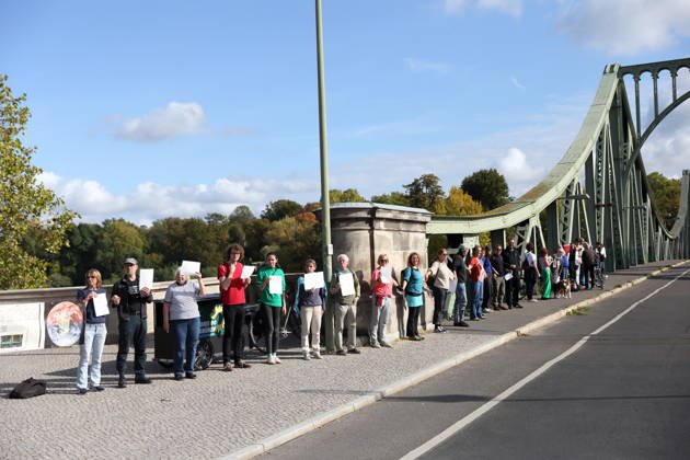 Demonstranten während einer Menschenkette für Klimaschutz und Demokratie auf der Glienicker Brücke in Potsdam, 3. Oktober 2026. Es brennt! Menschenkette Potsdam