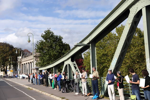 Demonstranten während einer Menschenkette für Klimaschutz und Demokratie auf der Glienicker Brücke in Potsdam, 3. Oktober 2026. Es brennt! Menschenkette Potsdam