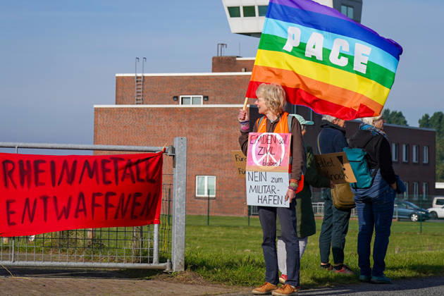 Protest in Emden vor dem Hintergrund der heutigen Pressekonferenz zur geplanten militärischen Nutzung des Emder Hafens. Demonstrantin mit PACE-Friedensfahne und Schildern Emden soll zivil bleiben! und Nein zum Militärhafen!. Bundeswehr, Boris Pistorius, Verteidigungsminister, Militär, Marine, NATO, Hafen, kritische Infrastruktur, Rüstung, Friedensbewegung, Demonstration, Emden, Niedersachsen. Copyright: xJOERANxSTEINSIEKx