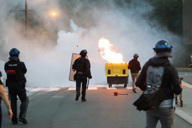 October 5, 2026, Anglet, Nouvelle Aquitaine, France: French police officers advance towards a burning waste container as sparks fly during a protest by high school students against the government outside the Cantau high school in Anglet, southwestern France, on October 5, 2026. Students have been blocking schools across France since September 21 to demand more teachers, smaller classes and better school buildings. Cantau was closed by authorities after clashes in recent days. Anglet France  - ZUMAb298 20261005_zsp_b298_005 Copyright: xJulesxBuonx