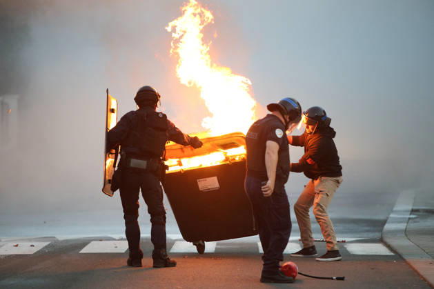 October 5, 2026, Anglet, Nouvelle Aquitaine, France: French police officers push a burning waste container during a protest by high school students against the government outside the Cantau high school in Anglet, southwestern France, on October 5, 2026. Students have been blocking schools across France since September 21 to demand more teachers, smaller classes and better school buildings. Cantau was closed by authorities after clashes in recent days. Anglet France  - ZUMAb298 20261005_zsp_b298_018 Copyright: xJulesxBuonx