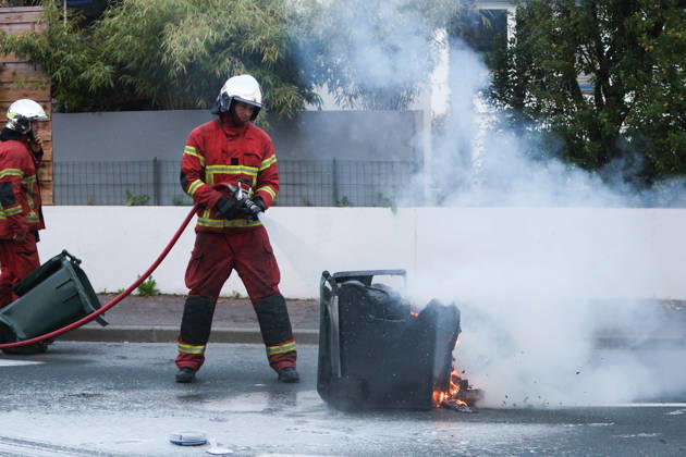 October 5, 2026, Anglet, Nouvelle Aquitaine, France: A firefighter extinguishes a burning waste container during a protest by high school students against the government outside the Cantau high school in Anglet, southwestern France, on October 5, 2026. Students have been blocking schools across France since September 21 to demand more teachers, smaller classes and better school buildings. Cantau was closed by authorities after clashes in recent days. Anglet France - ZUMAb298 20261005_zsp_b298_015 Copyright: xJulesxBuonx
