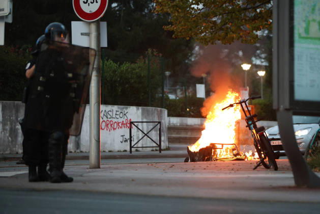 October 5, 2026, Anglet, Nouvelle Aquitaine, France: A riot police officer stands near a burning waste container and a parked bicycle during a protest by high school students against the government outside the Cantau high school in Anglet, southwestern France, on October 5, 2026. Students have been blocking schools across France since September 21 to demand more teachers, smaller classes and better school buildings. Cantau was closed by authorities after clashes in recent days. Anglet France  - ZUMAb298 20261005_zsp_b298_026 Copyright: xJulesxBuonx