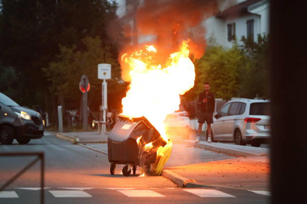 October 5, 2026, Anglet, Nouvelle Aquitaine, France: A waste container burns in the street as a man looks on during a protest by high school students against the government outside the Cantau high school in Anglet, southwestern France, on October 5, 2026. Students have been blocking schools across France since September 21 to demand more teachers, smaller classes and better school buildings. Cantau was closed by authorities after clashes in recent days. Anglet France - ZUMAb298 20261005_zsp_b298_027 Copyright: xJulesxBuonx