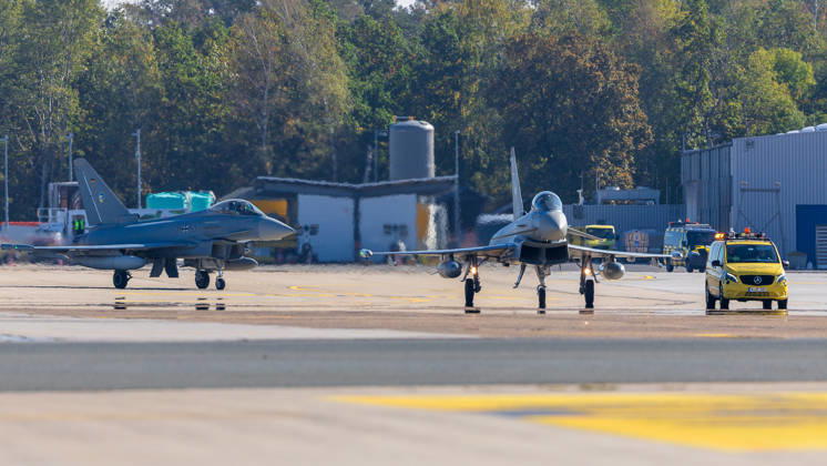 Eurofighter am Airport Nürnberg: Luftwaffe übt Dispersed Operation , Nürnberg, 05.10.2026 Zwei Eurofighter der Luftwaffe rollen auf dem Flughafen über das Vorfeld, begleitet von einem gelben Follow-me-Fahrzeug. Die Luftwaffe testet dort, wie Kampfjets und Einsatzkräfte zeitweise von einem zivilen Flughafen aus operieren können. Nürnberg Flughafen Bayern Deutschland