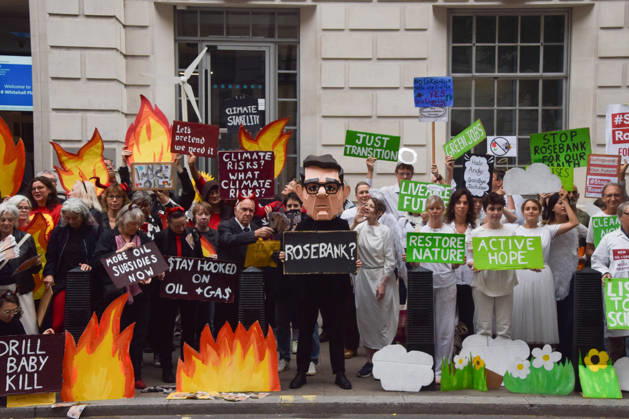 October 6, 2026, London, England, United Kingdom: Activists from the group Fossil Free London stage a protest against the Rosebank oil field and the Jackdaw gas field outside the Department for Energy Security and Net Zero. Activists dressed as angels urge a protester wearing an Andy Burnham mask to stop the fossil fuel projects in the North Sea while activists dressed as demons urge him to drill for more oil. London United Kingdom  - ZUMAv130 20261006_zip_v130_002 Copyright: xVukxValcicx