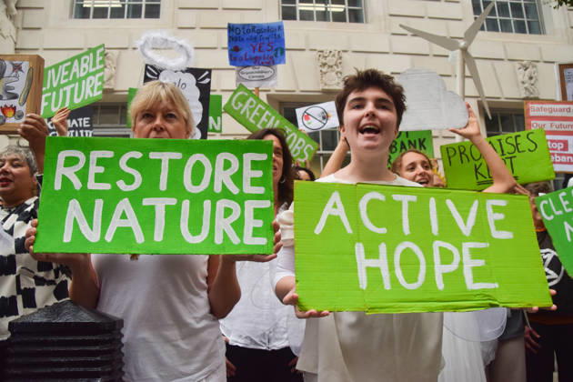 October 6, 2026, London, England, United Kingdom: Activists from the climate action group Fossil Free London staged a protest against the Rosebank oil field and the Jackdaw gas field outside the Department for Energy Security and Net Zero. Activists dressed as angels urged a protester wearing an Andy Burnham mask to stop the fossil fuel projects in the North Sea while activists dressed as demons urged him to drill for more oil. London United Kingdom  - ZUMAv130 20261006_zip_v130_011 Copyright: xVukxValcicx
