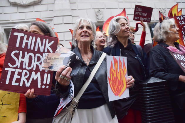 October 6, 2026, London, England, United Kingdom: Activists from the climate action group Fossil Free London staged a protest against the Rosebank oil field and the Jackdaw gas field outside the Department for Energy Security and Net Zero. Activists dressed as angels urged a protester wearing an Andy Burnham mask to stop the fossil fuel projects in the North Sea while activists dressed as demons urged him to drill for more oil. London United Kingdom  - ZUMAv130 20261006_zip_v130_016 Copyright: xVukxValcicx
