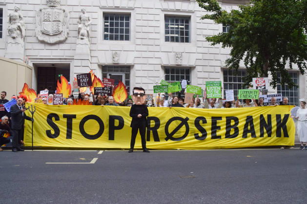October 6, 2026, London, England, United Kingdom: Activists from the climate action group Fossil Free London stage a protest against the Rosebank oil field and the Jackdaw gas field outside the Department for Energy Security and Net Zero. Activists dressed as angels urge a protester wearing an Andy Burnham mask to stop the fossil fuel projects in the North Sea while activists dressed as demons urge him to drill for more oil. London United Kingdom  - ZUMAv130 20261006_zip_v130_029 Copyright: xVukxValcicx