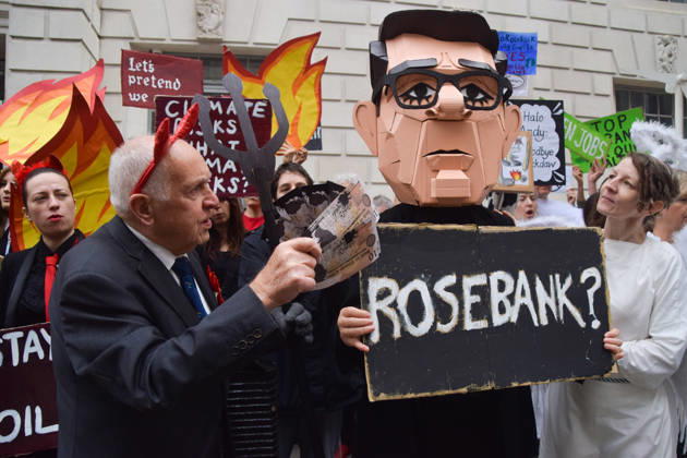 October 6, 2026, London, England, United Kingdom: Activists from the group Fossil Free London stage a protest against the Rosebank oil field and the Jackdaw gas field outside the Department for Energy Security and Net Zero. Activists dressed as angels urge a protester wearing an Andy Burnham mask to stop the fossil fuel projects in the North Sea while activists dressed as devils urge him to drill for more oil. London United Kingdom  - ZUMAv130 20261006_zip_v130_054 Copyright: xVukxValcicx