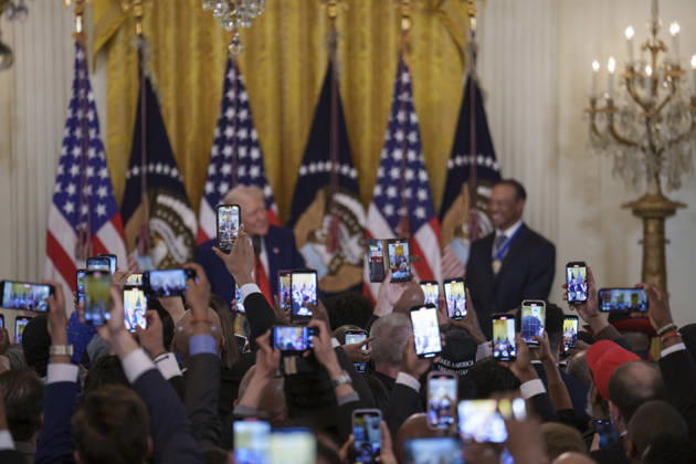October 6, 2026, Washington, Dc, United States of America: Guests take photos using their phones as U.S. President Donald Trump and golfer Tiger Woods appear at a reception honoring Black History Month in the East Room of the White House, February 20, 2025 in Washington, D.C. Trump introduced golfer Tiger Woods as a surprise guest at the reception in the East Room, where he praised Woods as one of the greatest athletes of all time. Washington United States of America - ZUMAp138 20261006_zaa_p138_018 Copyright: xJoycexBoghosian WhitexHousex