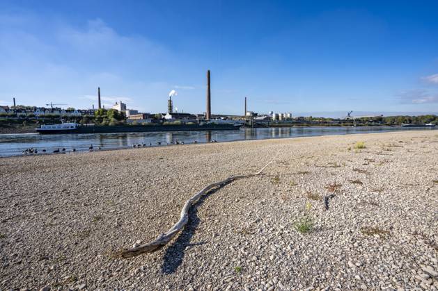Extremes Niedrigwasser am Rhein, hier bei Duisburg-Neuenkamp, trocken gefallenes Ufer, Pegel zur Zeit der Aufnahme bei 131cm in DU-Ruhrort, über 20cm unter der bisherigen je gemessnen Tiefstmarke von 2018, starke Einschränkungen für die Binnenschifffahrt, im Hintergrund das Sachtleben Chemie International Werk, NRW, Deutschland Rhein Niedrigwasser
