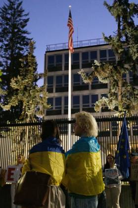 October 6, 2026, Warsaw, Masovian Voivodeship, Poland: Protesters draped in Ukrainian flags stand during a demonstration outside the US Embassy in Warsaw protesting the humanitarian crisis in Russian-occupied Oleshky. The protest was organized by Poland s Ukrainian diaspora as an appeal to Ukraine s international partners to step up diplomatic efforts to support civilians trapped in Oleshky with humanitarian aid and the possibility of evacuation. Warsaw Poland - ZUMAk204 20261006_zip_k204_020 Copyright: xRomanxKozielx