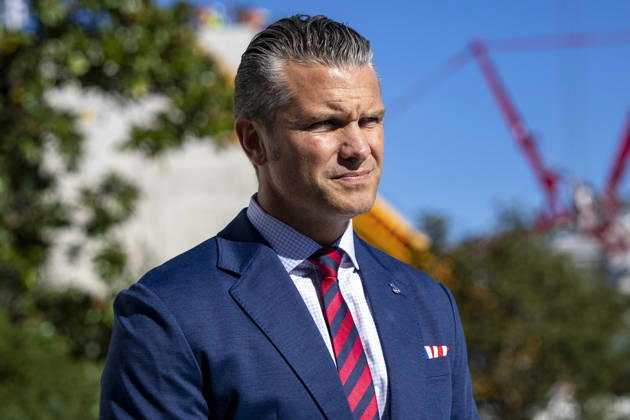 United States Secretary of War Pete Hegseth looks on as US President Donald J Trump speaks with reporters before boarding Marine One on the South Lawn of the White House in Washington, DC on Tuesday, October 6, 2026. The President is going to Baltimore, Maryland to deliver remarks at Anduril Industries, a tech company that builds robotic weapons and software for the military. Copyright: xBonniexCashx xPoolxviaxCNPx MediaPunchx