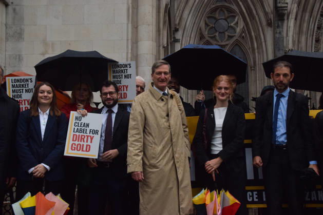 October 7, 2026, London, England, United Kingdom: Barrister and former Attorney General DOMINIC GRIEVE KC (centre) stands with the legal team and campaigners outside the Royal Courts of Justice as the legal case against the London Bullion Market Association begins. The LBMA is accused of incorrectly certifying gold from TanzaniaÃ¢â‚¬â ¢s North Mara mine as clean , despite reported human rights abuses connected to the mine. The case is being brought by the families of two Tanzanian men who were killed at the gold mine. London United Kingdom - ZUMAv130 20261007_zip_v130_009 Copyright: xVukxValcicx