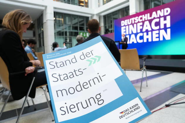 Statement des Bundesminister fuer Digtales zur Staatsmodernisierung Der Bericht in gebundener Form im Hintergrund Dr. Karsten Wildberger beim Statement zum Kabinettbeschluss des Berichts zu 1 Jahr Staatsmodernisierung, Berlin, 07.10.2026 Berlin Berlin Deutschland
