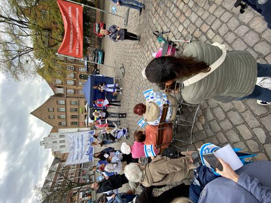 Flensburg, Schleswig-Holstein Flensburg gedenkt den Opfern des 7. Oktober 2023. Teilnehmer versammeln sich auf dem Südermarkt. Es werden Lieder gesungen und die Namen und Geschichten einzelner Opfer des Terroranschlages vorgelesen. Aufnahme vom 07.10.2026, Flensburg