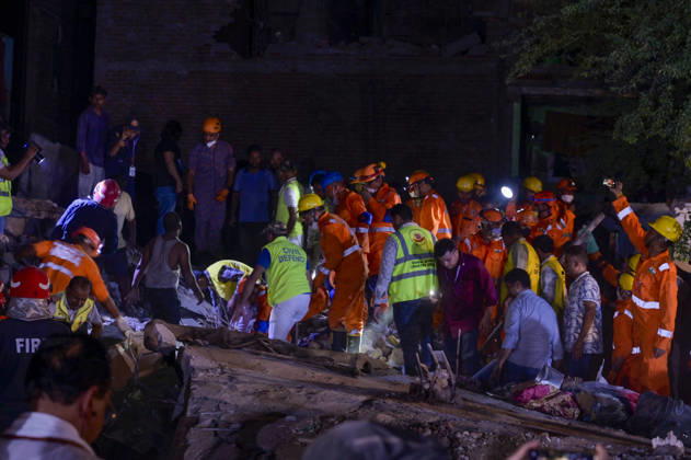 NEW DELHI, INDIA - OCTOBER 7: National Disaster Response Force (NDRF) jawans, Delhi Fire Service personnel, and local residents navigate heavy rubble during a search and rescue operation after a four-storey residential building collapsed in the New Seemapuri area of Shahdara on October 7, 2026, in New Delhi, India. The structural collapse occurred around 3:30 PM behind the local fish market, trapping multiple residents under concrete slabs and damaging two adjoining houses. At least one minor died while eight people were rescued and rushed to Rajiv Gandhi Super Speciality Hospital for emergency medical treatment as sniffer dogs and excavators worked late into the evening to locate remaining trapped survivors. (Photo by Raj K Raj Hindustan T