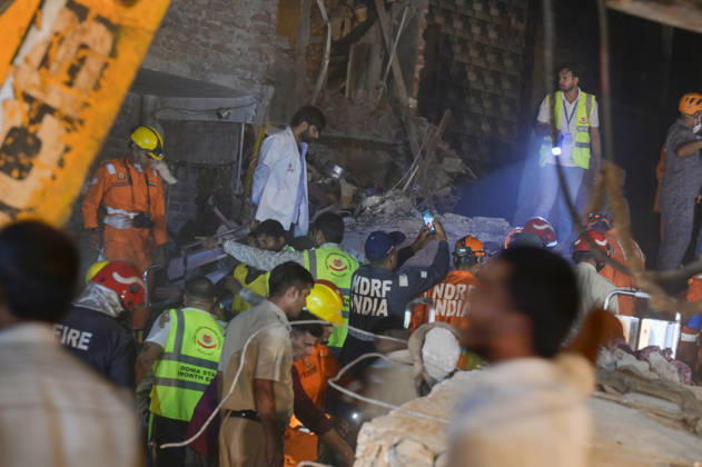 NEW DELHI, INDIA - OCTOBER 7: National Disaster Response Force (NDRF) jawans, Delhi Fire Service personnel, and local residents navigate heavy rubble during a search and rescue operation after a four-storey residential building collapsed in the New Seemapuri area of Shahdara on October 7, 2026, in New Delhi, India. The structural collapse occurred around 3:30 PM behind the local fish market, trapping multiple residents under concrete slabs and damaging two adjoining houses. At least one minor died while eight people were rescued and rushed to Rajiv Gandhi Super Speciality Hospital for emergency medical treatment as sniffer dogs and excavators worked late into the evening to locate remaining trapped survivors. (Photo by Raj K Raj Hindustan T