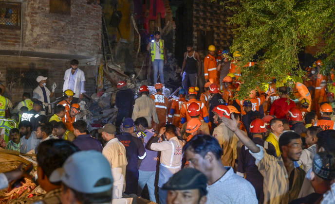 NEW DELHI, INDIA - OCTOBER 7: National Disaster Response Force (NDRF) jawans, Delhi Fire Service personnel, and local residents navigate heavy rubble during a search and rescue operation after a four-storey residential building collapsed in the New Seemapuri area of Shahdara on October 7, 2026, in New Delhi, India. The structural collapse occurred around 3:30 PM behind the local fish market, trapping multiple residents under concrete slabs and damaging two adjoining houses. At least one minor died while eight people were rescued and rushed to Rajiv Gandhi Super Speciality Hospital for emergency medical treatment as sniffer dogs and excavators worked late into the evening to locate remaining trapped survivors. (Photo by Raj K Raj Hindustan T
