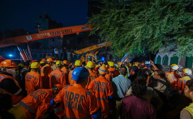 NEW DELHI, INDIA - OCTOBER 7: National Disaster Response Force (NDRF) jawans, Delhi Fire Service personnel, and local residents navigate heavy rubble during a search and rescue operation after a four-storey residential building collapsed in the New Seemapuri area of Shahdara on October 7, 2026, in New Delhi, India. The structural collapse occurred around 3:30 PM behind the local fish market, trapping multiple residents under concrete slabs and damaging two adjoining houses. At least one minor died while eight people were rescued and rushed to Rajiv Gandhi Super Speciality Hospital for emergency medical treatment as sniffer dogs and excavators worked late into the evening to locate remaining trapped survivors. (Photo by Raj K Raj Hindustan T
