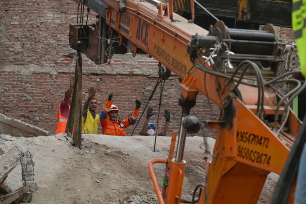 NEW DELHI, INDIA - OCTOBER 7: National Disaster Response Force (NDRF) jawans, Delhi Fire Service personnel, and local residents navigate heavy rubble during a search and rescue operation after a four-storey residential building collapsed in the New Seemapuri area of Shahdara on October 7, 2026, in New Delhi, India. The structural collapse occurred around 3:30 PM behind the local fish market, trapping multiple residents under concrete slabs and damaging two adjoining houses. At least one minor died while eight people were rescued and rushed to Rajiv Gandhi Super Speciality Hospital for emergency medical treatment as sniffer dogs and excavators worked late into the evening to locate remaining trapped survivors. (Photo by Raj K Raj Hindustan T