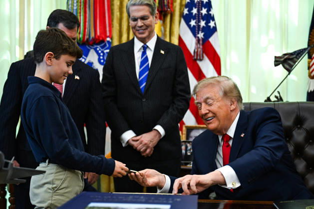 Trump Makes Oval Office Announcement WASHINGTON, DC - OCT. 7: US President Donald Trump hands a challenge coin and a pen to a child during an announcement on Trump Accounts in the Oval Office on Wednesday, Oct. 7, 2026 at the White House in Washington, D.C. (Photo by Annabelle Gordon Pool For The Washington Post) Washington DC United States  Copyright: xPool ABACAx