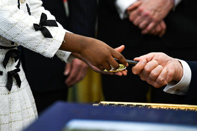 Trump Makes Oval Office Announcement WASHINGTON, DC - OCT. 7: US President Donald Trump hands a challenge coin and a pen to a child during an announcement on Trump Accounts in the Oval Office on Wednesday, Oct. 7, 2026 at the White House in Washington, D.C. (Photo by Annabelle Gordon Pool For The Washington Post) Washington DC United States  Copyright: xPool ABACAx