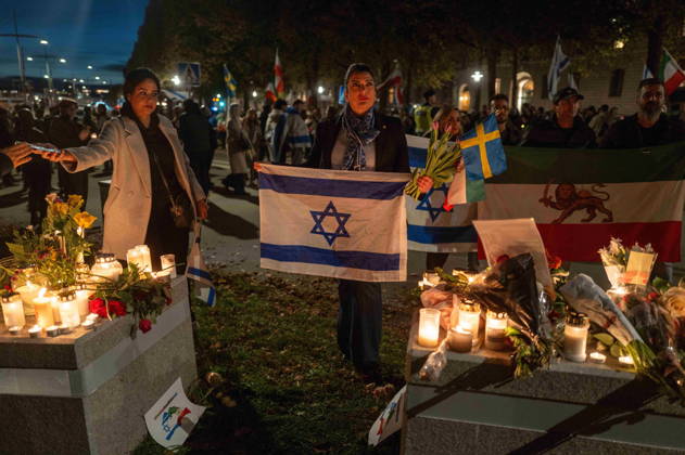 October 7, 2026, Stockholm, Stockholm County, Sweden: STOCKHOLM, SWEDEN - OCTOBER 7, 2026: People gather outside the Israeli Embassy in Stockholm to show support for Israel and remember the victims of the October 7 attacks. Participants place flowers and light candles at a memorial as Israeli and Iranian flags are displayed during the gathering Stockholm Sweden  - ZUMAa136 20261007_zap_a136_011 Copyright: xJoelxLindhex