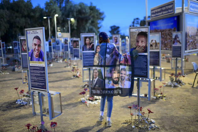 Reim Nova Memorial Marks Anniversary A woman wrapped in a blanket printed with memorial portraits walks among the plaques at the Nova music festival memorial site near Reim, southern Israel, on October 7, 2026. The Hamas-led attack on Israel on October 7, 2023, killed about 1,200 people and saw 251 taken hostage; more than 350 people were killed at the Nova festival. Memorial events marking the third anniversary were held at the site throughout the day. Reim Southern District Israel Copyright: xTomerxNeubergx