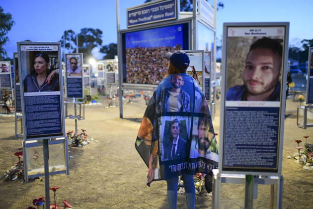 Reim Nova Memorial Marks Anniversary A woman wrapped in a memorial blanket stands between two portrait plaques at the Nova music festival memorial site near Reim, southern Israel, on October 7, 2026. The Hamas-led attack on Israel on October 7, 2023, killed about 1,200 people and saw 251 taken hostage; more than 350 people were killed at the Nova festival. Memorial events marking the third anniversary were held at the site throughout the day. Reim Southern District Israel Copyright: xTomerxNeubergx