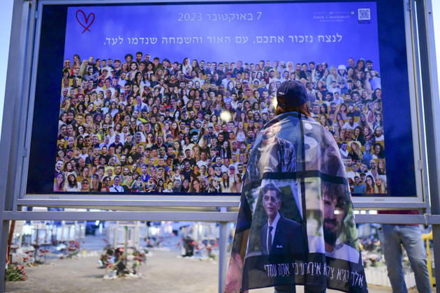 Reim Nova Memorial Marks Anniversary A woman wrapped in a memorial blanket looks at a large group photograph at the memorial site at the Nova music festival memorial site near Reim, southern Israel, on October 7, 2026. The Hamas-led attack on Israel on October 7, 2023, killed about 1,200 people and saw 251 taken hostage; more than 350 people were killed at the Nova festival. Memorial events marking the third anniversary were held at the site throughout the day. Reim Southern District Israel Copyright: xTomerxNeubergx