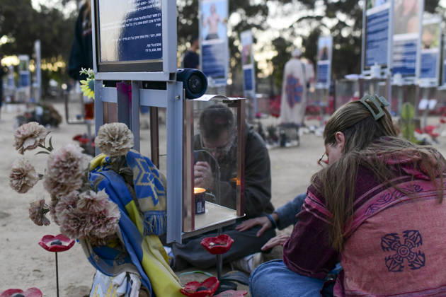 Reim Nova Memorial Marks Anniversary Mourners sit beside a glass memorial box containing a candle and personal items at the Nova music festival memorial site near Reim, southern Israel, on October 7, 2026. The Hamas-led attack on Israel on October 7, 2023, killed about 1,200 people and saw 251 taken hostage; more than 350 people were killed at the Nova festival. Memorial events marking the third anniversary were held at the site throughout the day. Reim Southern District Israel Copyright: xTomerxNeubergx