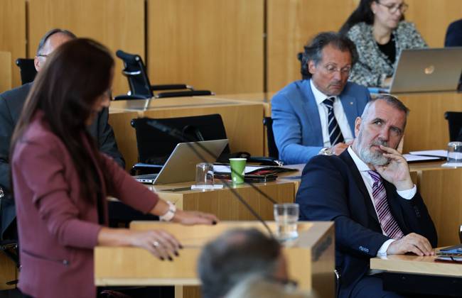 Sonderplenum Thueringer Landtag 07.10.2026, Erfurt, Thueringer Landtag, 55. Plenarsitzung, Sonderplenum, Verhandlungsgegenstand ist die Aufloesung des 8. Thueringer Landtags gemaess Artikel 50 Abs. 2 Satz 1 Nr. 1 der Verfassung des Freistaats Thueringen Antrag der AfD im Bild: Anke Wirsing (fraktionslos) am Rednerpult, Minister fuer Digitales und Infrastruktur Steffen Schuetz (Thueringen.Gerecht) sieht zu ihr